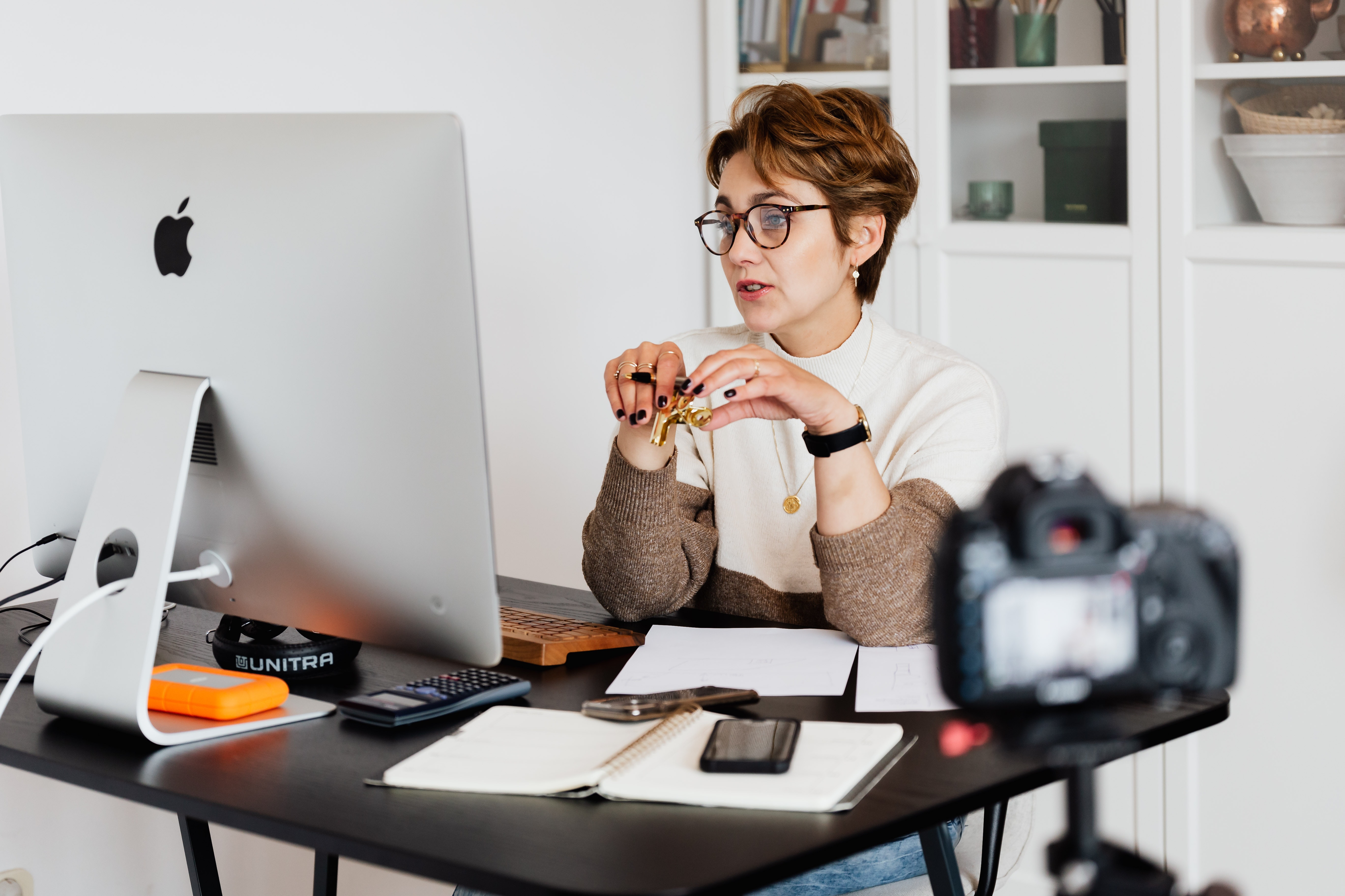 Mulher elegante sentada a frente de um computador representando uma psicóloga que possui o equilibrio entre atendimento e administração